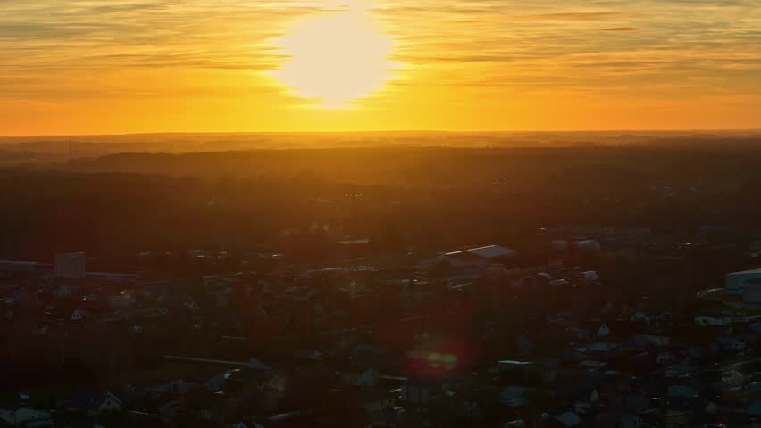 Golden sunset over the city, panoramic aerial view filmed by drone