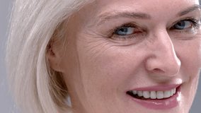 Close-up portrait of Old woman uses lipstick or a pomade. Senior female applies make up or cosmetics to the lips. Facial skin care in old age. Mature elderly lady. Concept of natural beauty. - Powered by Shutterstock - Get 15% off with code: PIKWIZARD15