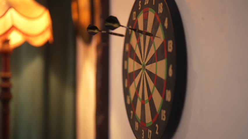 Three imprecise dart throws miss the dartboard’s target, a casual and unrefined attempt in a game
