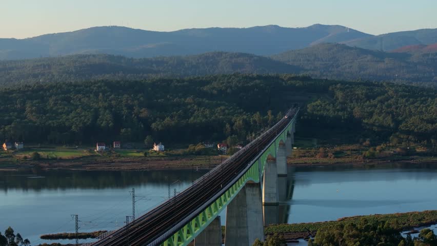 An aerial footage of a train moving on Ulla River Viaduct crossing Ulla River on a sunny day in Isorna - Catoira, A Coruna, Spain