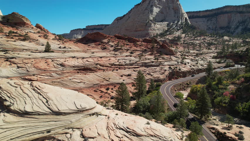 Aerial shot tracking a vehicle driving through Zion National Park