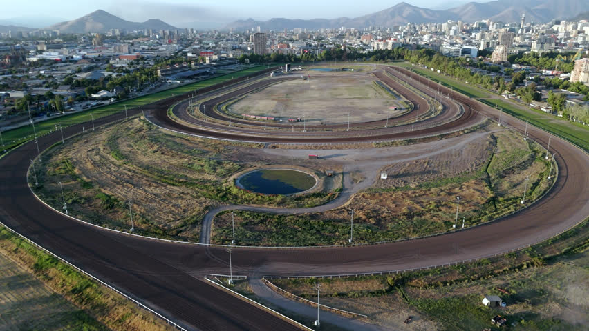 Aerial establishing wide overview pan of Club Hípico de Santiago horse track in Chile, surrounded by dense urban cityscape