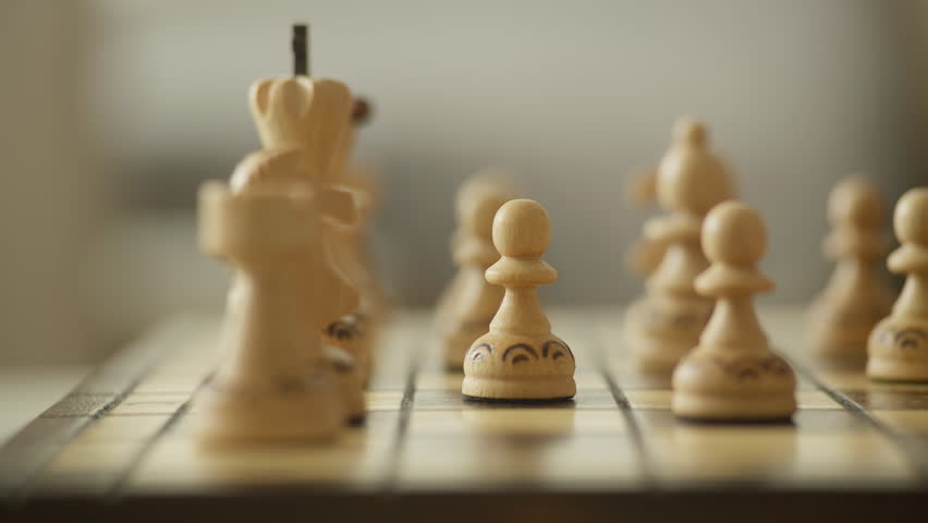 Hand Moving Chess Piece on Wooden Chessboard