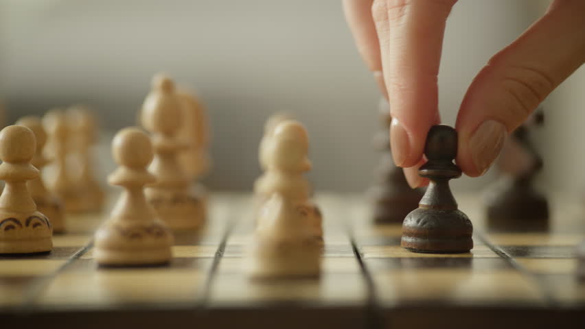 Hand Moving Chess Piece on Wooden Chessboard - Powered by Shutterstock - Get 15% off with code: PIKWIZARD15