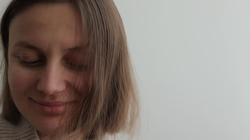 Young woman with static electricity on her natural short hair after combing hair with hairbrush on wall background. Girl with electrified hair. Staticky hair. Beauty treatment.