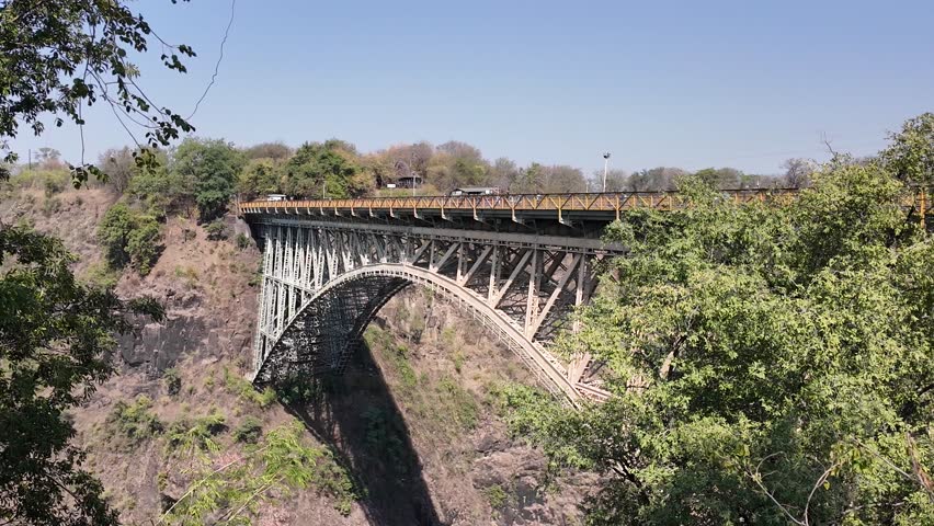 Bridge Border At Victoria Falls Northern Rhodesia Zambia. Elevated Road Bridge Symbol Of The City Viewed From Above. Landscape Dramatic Clouds Waterfall Tropical. Landscape Waterfall Panoramic.
