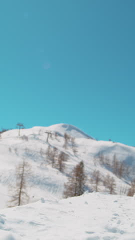 SLOW MOTION TIME WARP, CLOSE UP: Extreme snowboarder does a cool spinning big air trick on sunny winter day. Active tourist snowboarding in the Alps rides off a kicker and performs a spinning grab.