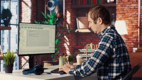 Man in home office stretches back while looking at UI on PC screen, feeling fatigued while executing programming code. IT developer feeling backpain, relieving pain, writing and testing code, camera B - Powered by Shutterstock - Get 15% off with code: PIKWIZARD15