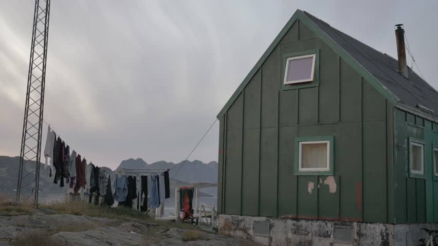 Typical colorful Greenlandic Nordic-style houses with clothes hanging on a rope to dry in the breeze. Filmed in the late afternoon in Kulusuk, East Greenland. Similar shots available in my portfolio.