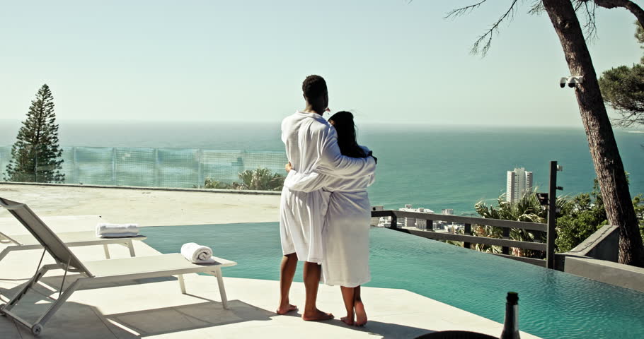 Champagne, pool and couple cheers at hotel for anniversary, honeymoon and vacation. Hospitality, love and man and woman embrace, hug and toast with alcohol for romance on holiday, travel and weekend