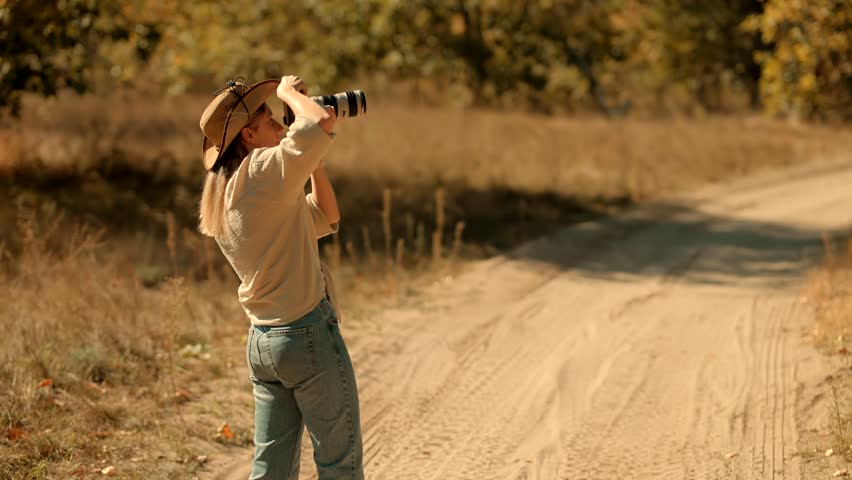 Tourist Photo Camera On Safari Masai Mara Kenya Safari.Professional Camera For Photograph Wildlife.  Safari In Savannah Photographer Takes Photo In Savannah. African Walking Safari. Kenya and Tanzania
