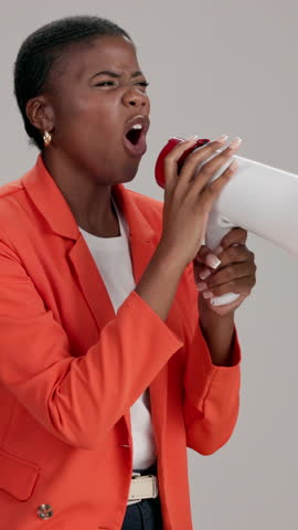 Black woman, loudspeaker and protest in studio with shout, anger and call to action by background. African person, bullhorn and voice opinion for empowerment, inclusion or equal pay with announcement