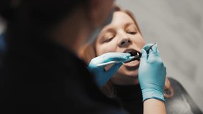 Medical examiner in stomatological clinic, adult woman sitting in dental chair. Portrait of female patient of dental clinic during dentist appointment, hands of professional stomatologist with tools - Powered by Shutterstock - Get 15% off with code: PIKWIZARD15
