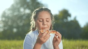 Smiling child enjoying pizza at picnic in nature. Happy girl eating pizza outdoors during family picnic. Sunny day picnic with pizza brings joy to child. Fun outdoor pizza picnic in nature with child. - Powered by Shutterstock - Get 15% off with code: PIKWIZARD15
