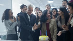 A cheerful group of corporate office employees or coworkers celebrating, enjoying the birthday of a female colleague by surprising her with a cake and party in a modern start up business workplace - Powered by Shutterstock - Get 15% off with code: PIKWIZARD15