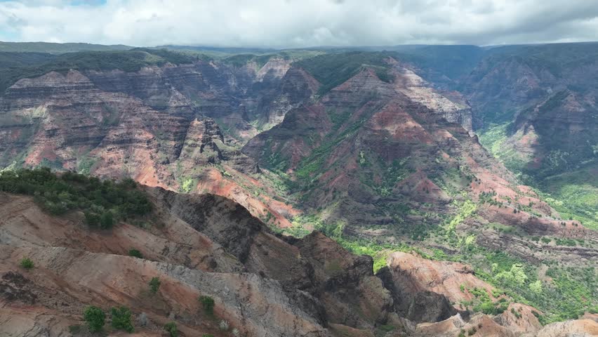 The perspective above Waimea Canyon, a mesmerizing mix of scarlet cliffs, verdant valleys, and winding waterways.