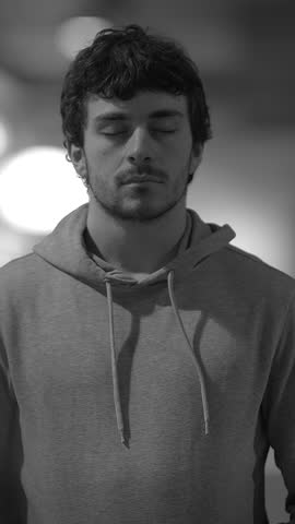 A Thoughtful Young Man Wearing a Hoodie with His Eyes Gently Closed in Deep Contemplation
