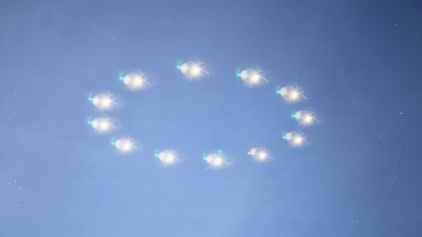 A simulated handheld bad cellphone video view of a group of mysterious drones or UFOs flying and hovering in unison in a circle pattern over a rural area at night.	
