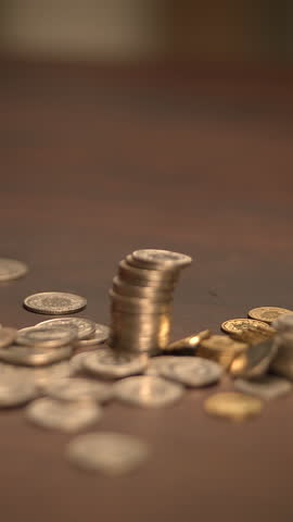 Piles of Coins Arranged Neatly on a Rustic Wooden Table Surface, Symbolizing Wealth