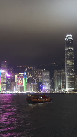 Hong Kong at night. Boats in the Victoria Harbour and Hong Kong Central. Vertical video