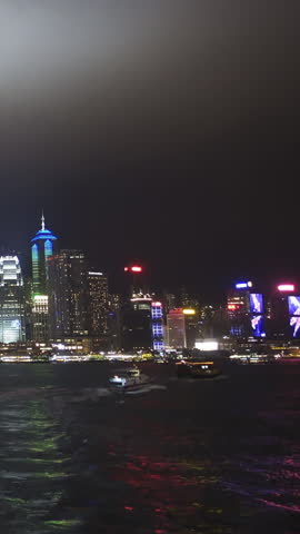 Hong Kong at night. Boats in the Victoria Harbour and Hong Kong Central. Vertical video