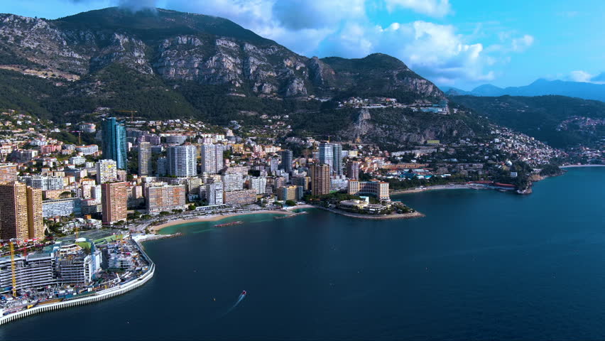 A breathtaking aerial footage of Monte Carlo, showcasing luxury skyscrapers, Mediterranean coastline, and scenic mountainous backdrop. Perfect for travel, urban, and luxury lifestyle themes.