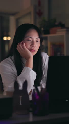 Night, woman and tired at computer with burnout, exhausted and waiting for software update. Graphic designer, technology and overworked in office with deadline, fatigue and thinking with boredom