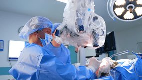 Professional male surgeon sitting at the patient's head performs brain surgery. Doctor looks at microscope carting out operation. - Powered by Shutterstock - Get 15% off with code: PIKWIZARD15