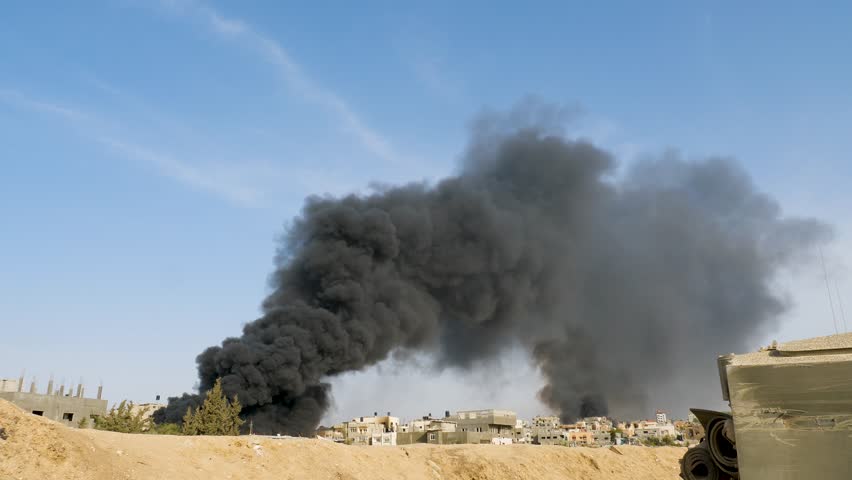 Thick black smoke rises high among buildings destroyed by Israeli missile attacks in the Palestinian city of Rafah