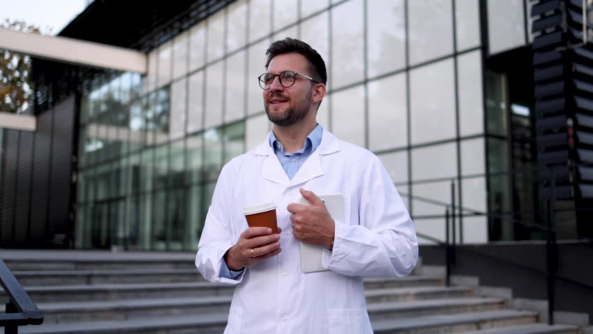 Video portrait of a young doctor taking a break in front of his clinic
