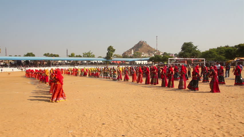 PUSHKAR, INDIA - NOVEMBER 21: Indian girls in colorful ethnic attire dancing at