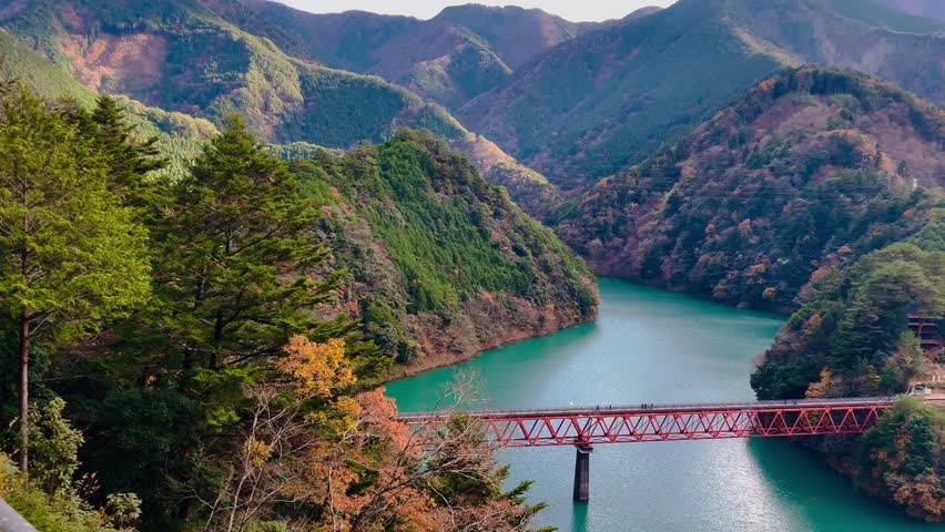 Natural scenery of a beautiful green lake between the mountains. decorated with railroad tracks along the lake in okuoikojo station shizuoka japan