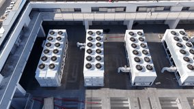 "Aerial drone view of industrial HVAC systems, air conditioning units, ventilation fans, and piping installed on a rooftop of commercial buildings. The image highlights modern climate control infra - Powered by Shutterstock - Get 15% off with code: PIKWIZARD15