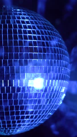 Mesmerizing reflections from a spinning disco ball in a vibrant night atmosphere. Vertical video