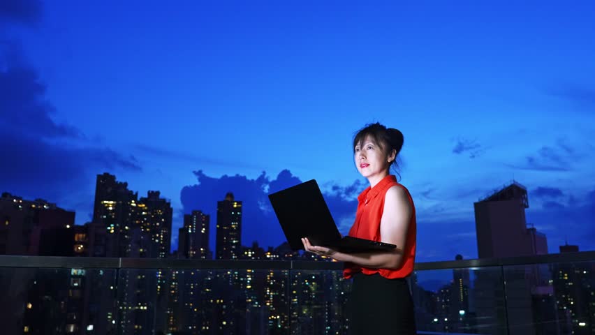 Young beautiful asian businesswoman with laptop on the building rooftop at city night - Powered by Shutterstock - Get 15% off with code: PIKWIZARD15