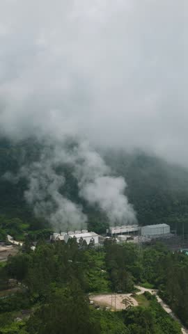 Drone view of Geothermal Production Field with steam and pipes. Renewable energy production at a power station. Mindanao, Philippines. Vertical view.