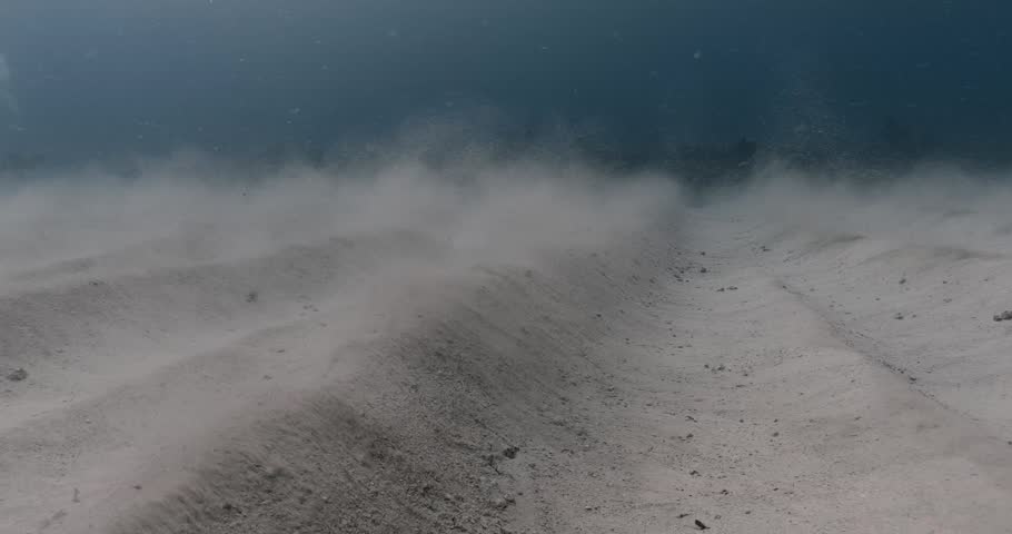 A low-angle view captures the effects of waves moving sand on the ocean floor, with small clouds of sand drifting off the crests of mounds. Check my portfolio for more ocean footage.
