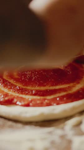 Cook Spreads Tomato Sauce On Raw Pizza Dough.