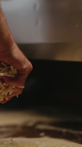 Chef Sprinkles Cheese On Round Piece Of Pizza Dough.