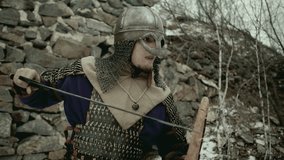 Medieval warrior wearing chainmail armor and metal helmet, holding sword and shield, shouting and running outside stone fortress as attacking enemy in combat - Powered by Shutterstock - Get 15% off with code: PIKWIZARD15