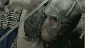 Brutal medieval warrior armored in chainmail and helmet, holding shield and stabbing enemy with sword in battle - Powered by Shutterstock - Get 15% off with code: PIKWIZARD15