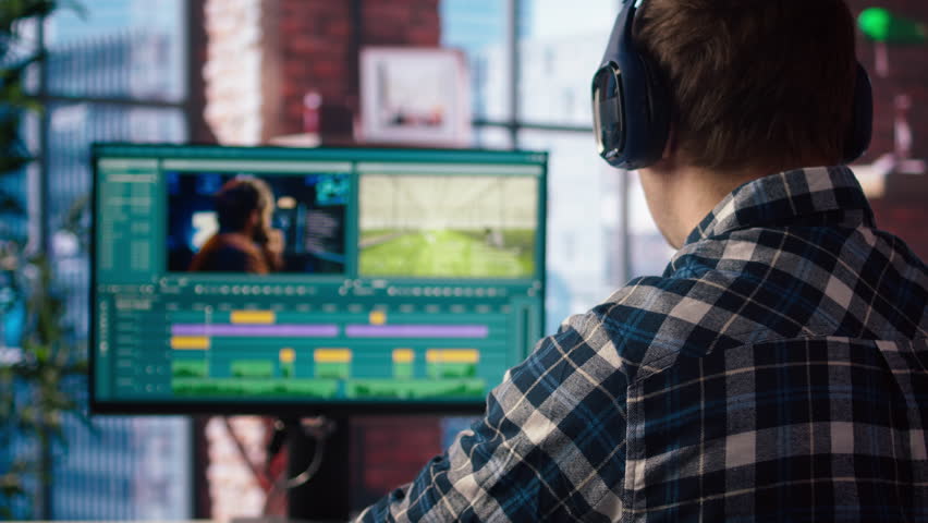 Video editor wearing headphones to polish raw footage and improve audio quality, zoom out shot. Videographer professionally adjusting clips, applying sound effects to film, camera A