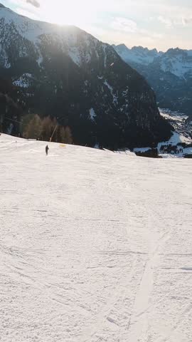 First-person view FPV first-person point of view POV of alpine skiing in Dolomites. Ski resort piste with people skiing in Dolomites in Italy. Ski area Belvedere. Canazei, Italy
