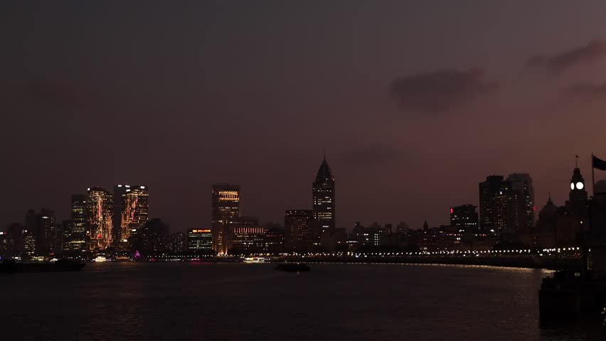 Shanghai city night view. Huangpu river with illuminated skyline of city, scyscrappers reflecting on water. Vibrant and modern illuminated cityscape. Chinese urban scene