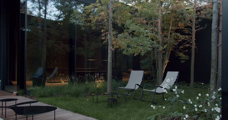 A serene view of a modern home's exterior, showcasing sleek design and an inviting garden with comfortable outdoor chairs. Modern Home Exterior with Elegant Garden and Relaxing Chairs