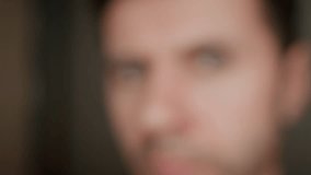 Man looks curiously into camera. Intense gaze with gray eyes. Male face with focused expression - Powered by Shutterstock - Get 15% off with code: PIKWIZARD15