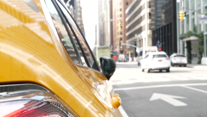 New York City. Yellow taxi car on Manhattan street. Taxi cab on Midtown Lexington avenue. Medallion taxicab rear view on Lex ave waiting for people or passengers on road. Urban scene in United States.