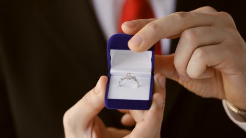 groom or salesman holding a box with wedding ring