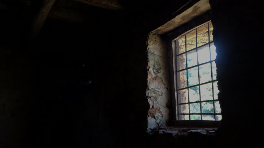 Man at the window with old banister in abandoned jail
