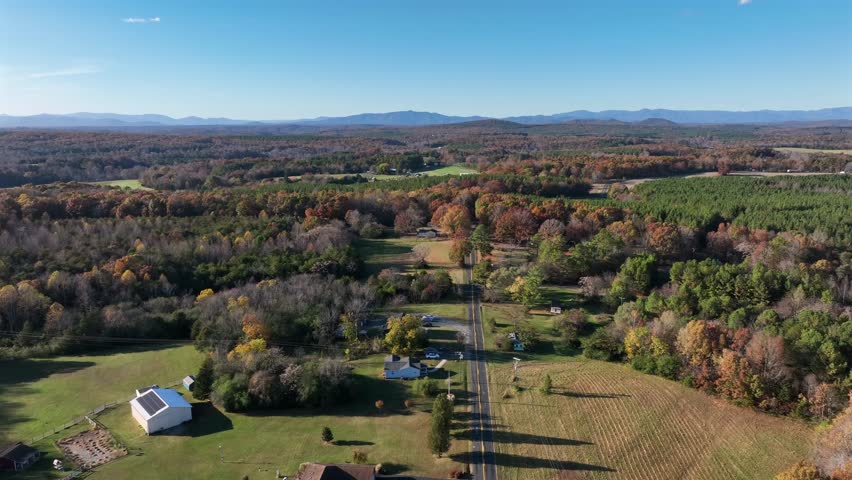 Main Street of American town in rural area. Sunny day in autumn season. Houses and homes in suburb of Michigan.Aerial wide shot.